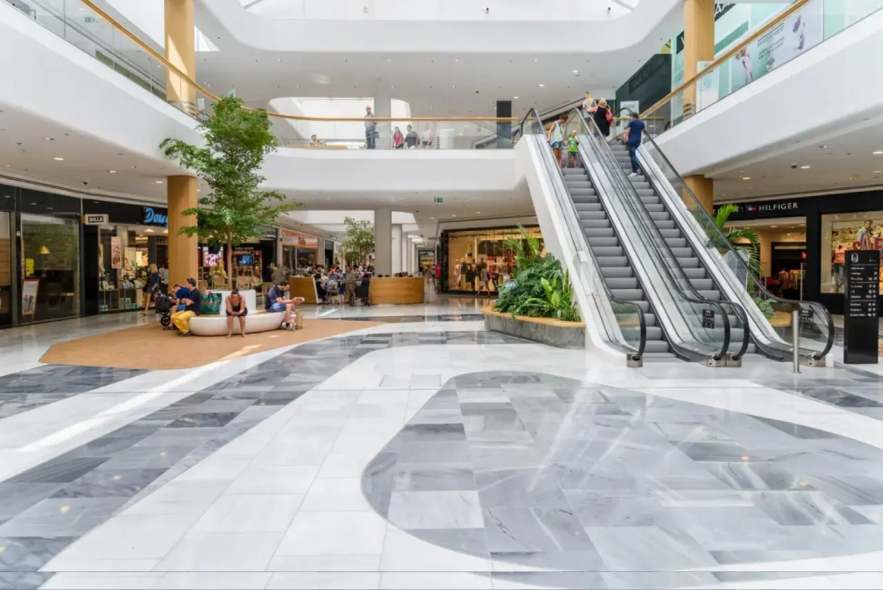 Shopping mall atrium with escalators and shoppers