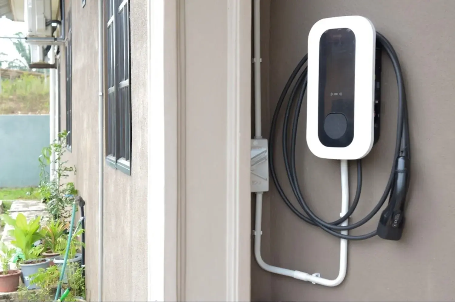 Wall-mounted EV charger on the side of a house