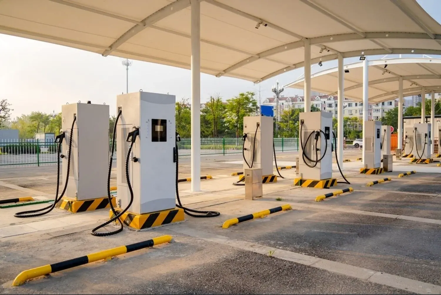 Row of public EV chargers under a canopy in an open car park